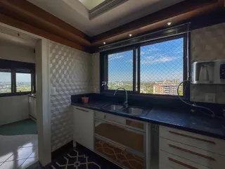 Vista da cozinha com janela para a paisagem urbana.