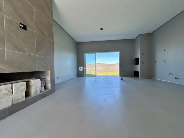 Ambiente interno amplo com piso de concreto e paredes lisas.