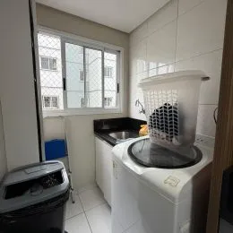 Foto interna de um banheiro com revestimento de azulejos brancos.