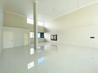 Espaço interno amplo com paredes brancas e piso claro.