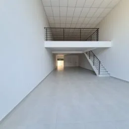 Hall de entrada com paredes brancas e escadaria.