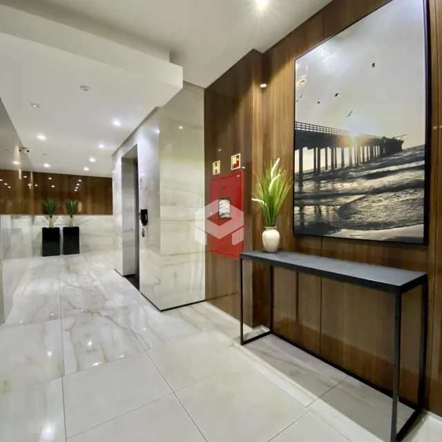 Hall de entrada com piso de mármore e painéis de madeira.
