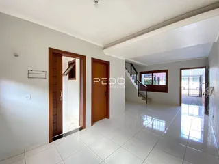 Interior de um corredor com portas de madeira e piso de cerâmica branca.