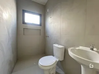 A foto mostra o interior de um banheiro com azulejos brancos.