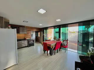 Sala de estar e cozinha com portas de vidro que dão para o quintal.