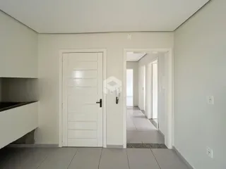 Hall de entrada com portas brancas e piso de cerâmica clara.