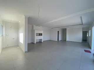 Ambiente interno amplo com piso de porcelanato e paredes brancas.