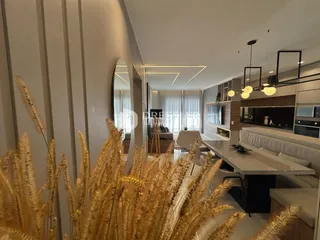 Sala de estar moderna com grandes janelas e decoração de grama dourada.