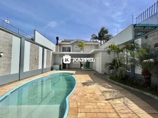 Fachada de casa com piscina e área externa pavimentada em Lajeado.