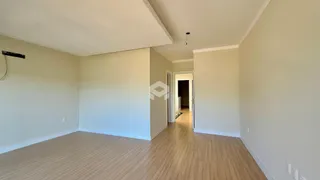 Vista interna de um ambiente com piso de madeira clara e paredes brancas.