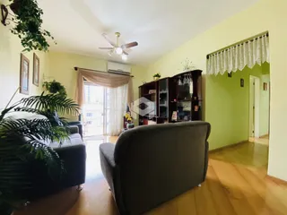 Sala de estar com piso de madeira e grandes janelas na residência.
