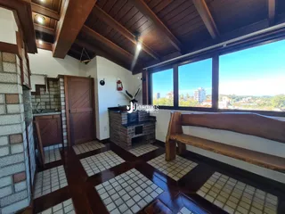 Sala de estar com piso de cerâmica e grandes janelas com vista para a paisagem.