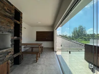 Sala de estar com parede de pedra e porta de vidro que oferece vista para o exterior.