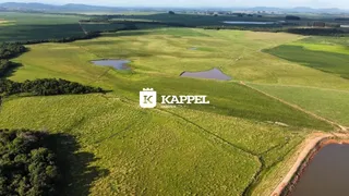 Vista aérea de uma área rural com campos verdes e pequenos corpos d'água.