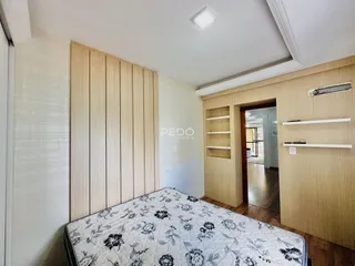 Quarto com parede de painel de madeira e cama no ambiente.