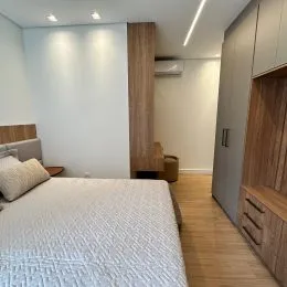 Foto de um quarto com cama de casal e paredes brancas.