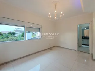 Sala de estar com piso de porcelanato claro e grande janela.