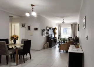 Sala de estar com piso de cerâmica e móveis de madeira clara.