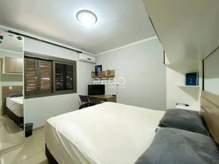 Quarto com cama e armários de madeira na sala.