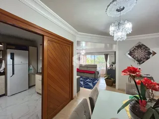 Interior de uma sala de estar com porta de madeira e decoração de teto em Lajeado.