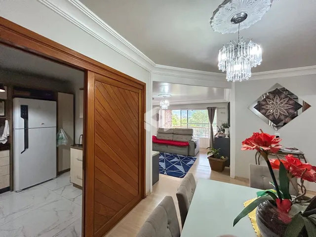 Interior de uma sala de estar com porta de madeira e decoração de teto em Lajeado.