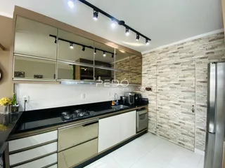 Cozinha moderna com armários brancos e bancadas escuras.