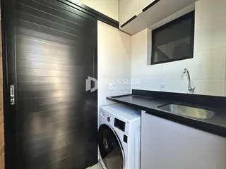Cozinha com pia e máquina de lavar roupa em ambiente interno.