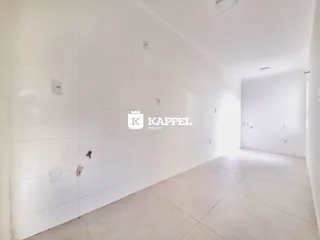 Vista interna de um corredor longo e branco em um imóvel.