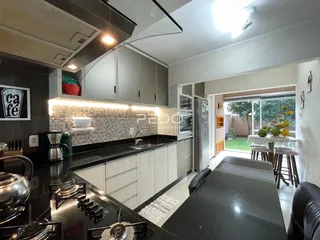Foto de uma cozinha moderna com armários e bancadas escuras.
