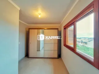 Interior com paredes claras e uma janela que oferece uma vista externa.