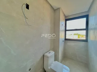 Interior de um banheiro com piso claro e janela.