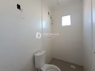 Foto de um banheiro interno com paredes brancas e um vaso sanitário branco.