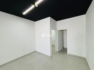 Ambiente interno de uma sala com teto preto e piso claro.