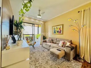 Sala de estar iluminada com sofá e decoração em um imóvel no Brasil.