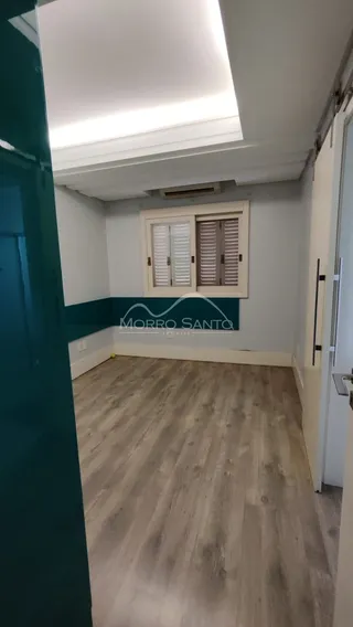 Foto de um cômodo interno com piso de madeira e janela.