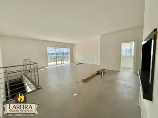 Ambiente interno de uma sala ampla com vista para o exterior.