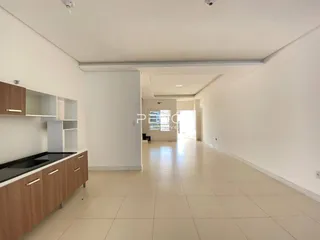 Corredor interno de uma residência com piso de cerâmica clara e paredes brancas.