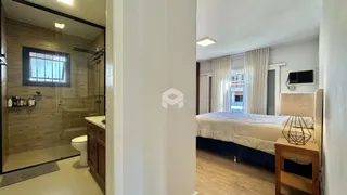 Quarto com banheiro e piso de madeira em um imóvel no Brasil.