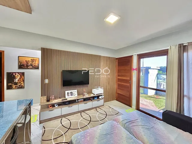 Sala de estar com parede de madeira e televisão.