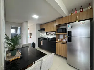 Sala de jantar e cozinha moderna com armários e geladeira.