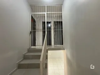 Vista do hall com escadas e grade de metal.