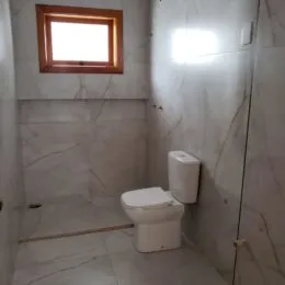Foto de um banheiro com revestimento branco.