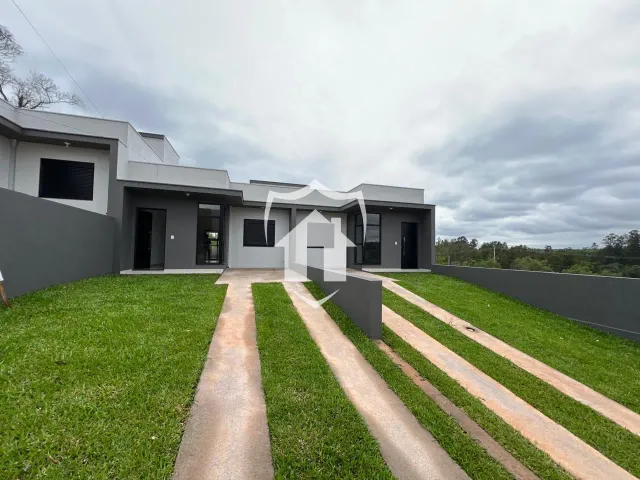 Fachada moderna de uma residência em Lajeado, Brasil, com jardim gramado em primeiro plano.