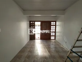 Hall de entrada com piso de cerâmica e portas de madeira escuras.