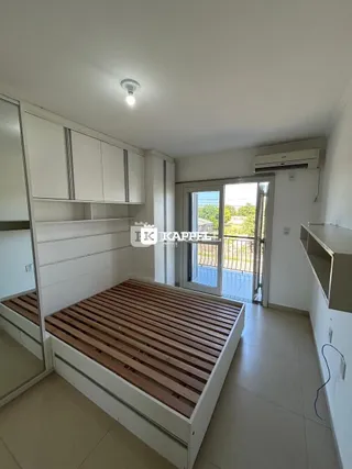 Quarto com cama de madeira e armários brancos em um ambiente claro.