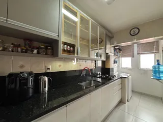 Vista da cozinha com armários superiores e bancada escura.