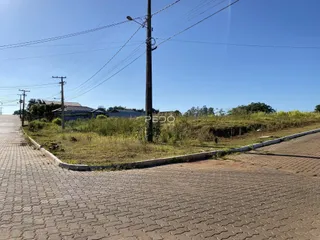 Vista externa da propriedade com área gramada e rua pavimentada.