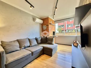 Sala de estar com sofá grande e piso de madeira.