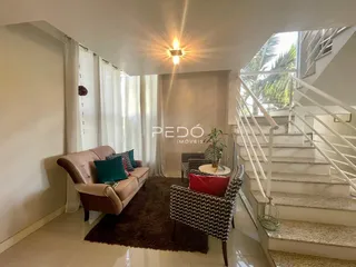 Sala de estar com sofá e poltronas em ambiente claro.