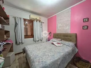 Quarto com paredes rosa e cabeceira de estofado em Lajeado, Brasil.